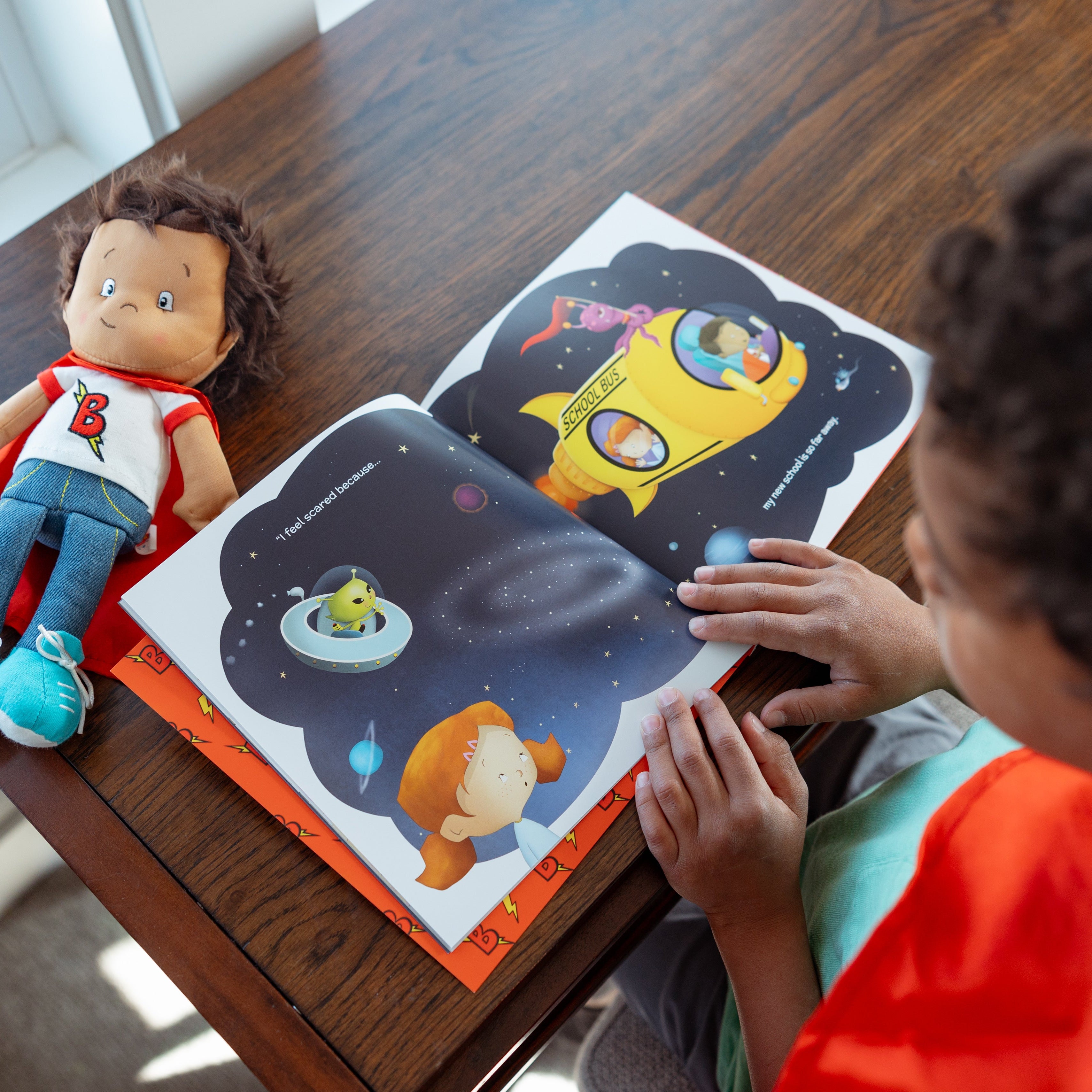 child reading a team supercrew book with a benny the brave doll nearby
