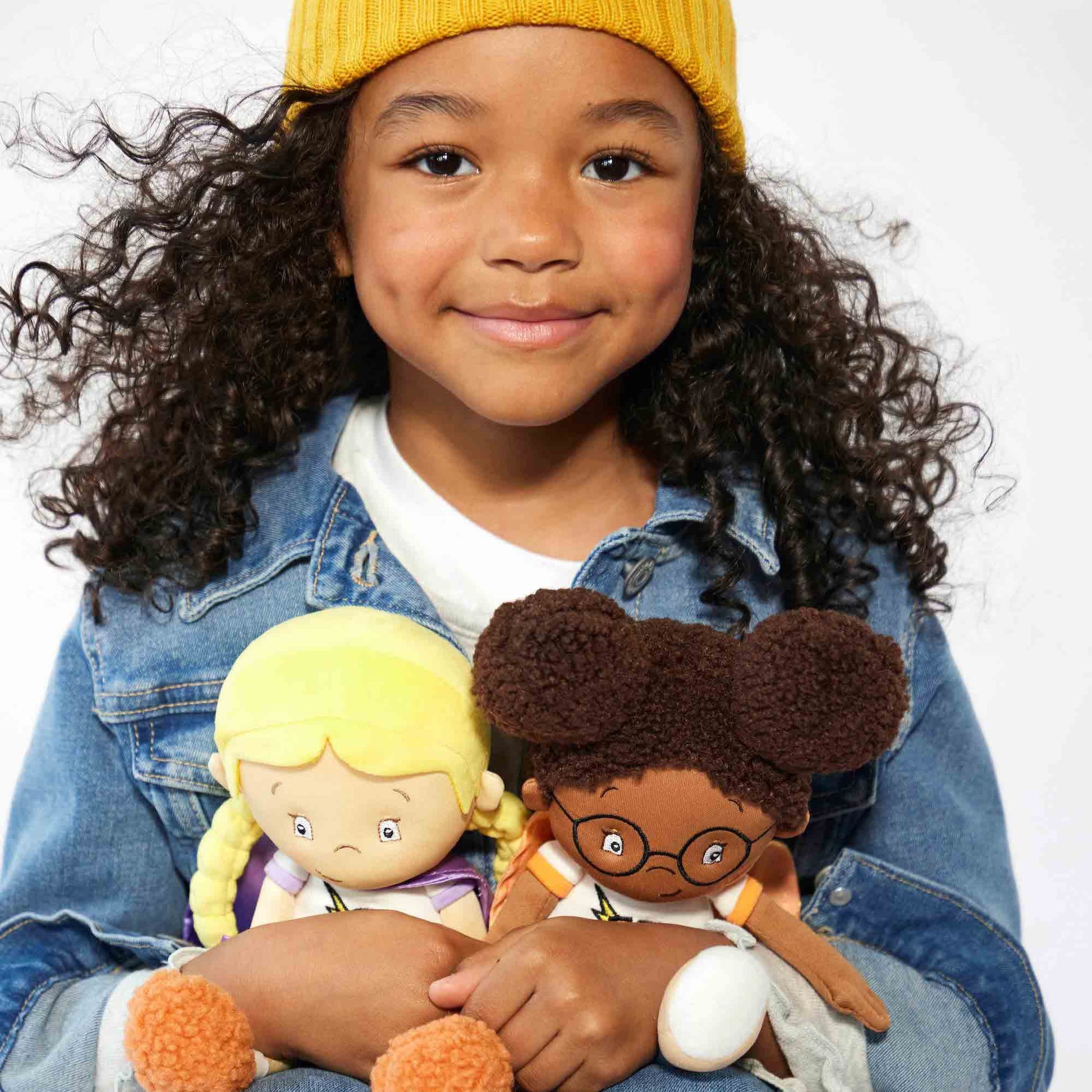child holding team supercrew plush toys chloe the calm and keisha the kind