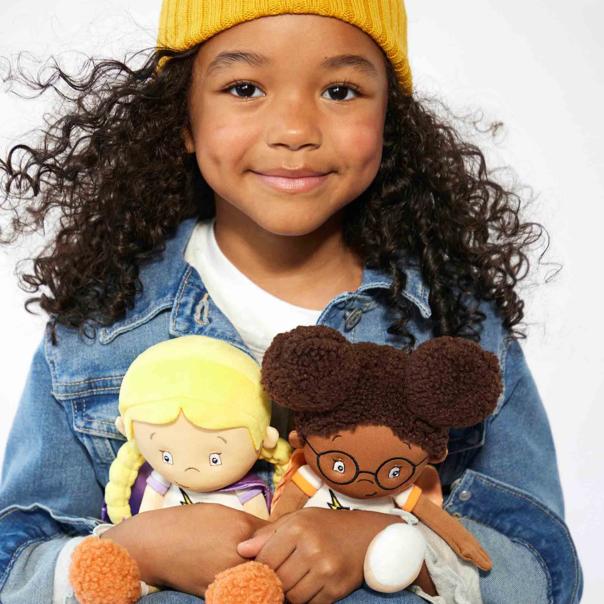 child holding team supercrew plush toys chloe the calm and keisha the kind